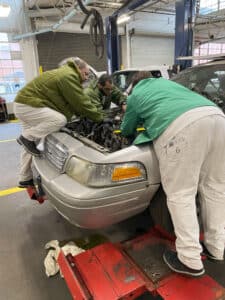 Lee students in the Texas State Penitentiary at Huntsville work to repair a car as part of their training in the auto mechanics program. 