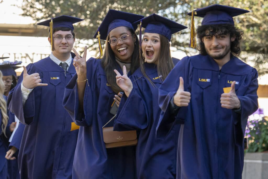 Four LSUE students in graduation attire pose for the camera