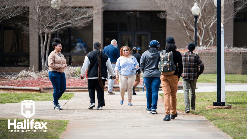 Students walk in multiple directions in front of a campus building.